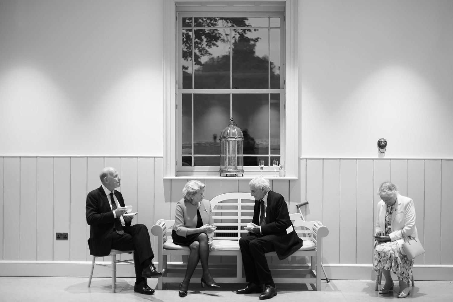 Black and white panoramic series of quiet moments at a formal venue.