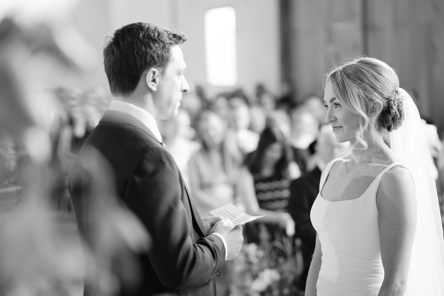 Black and white wedding ceremony candid moments in elegant venue setting.