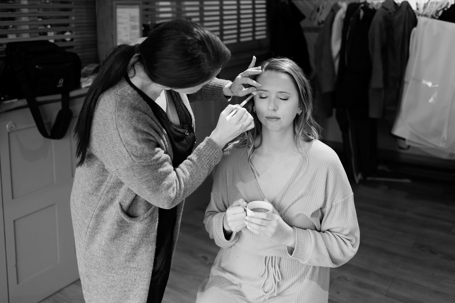Wedding day preparation with final makeup touches being applied.