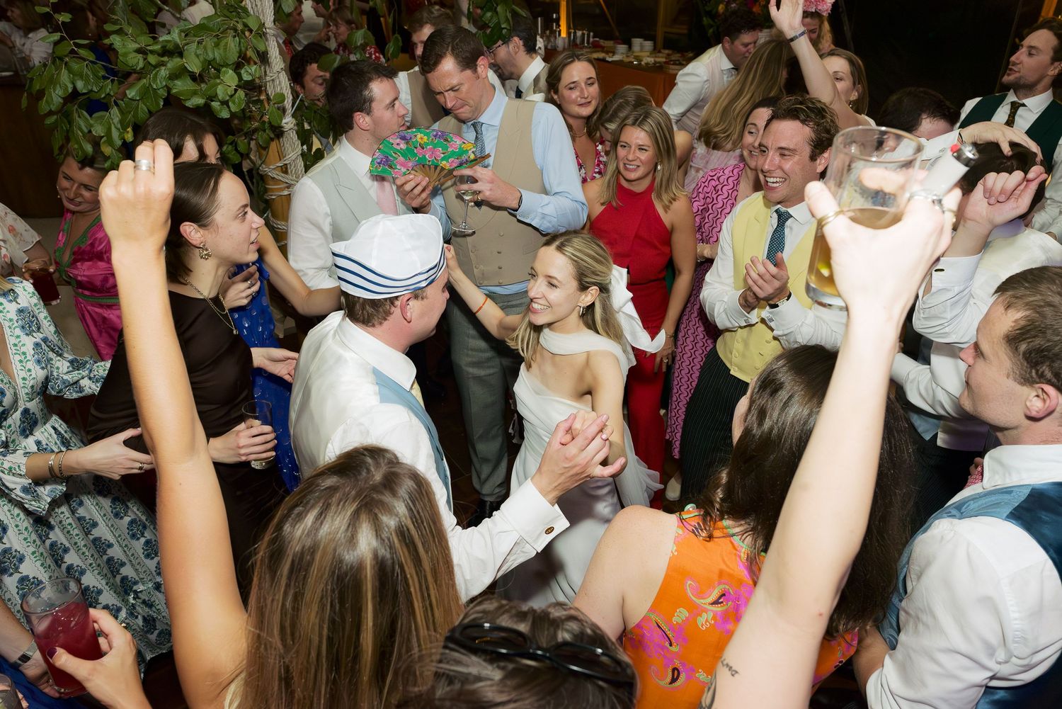A crowded dance floor filled with energetic party guests dancing and celebrating together at an indoor event.