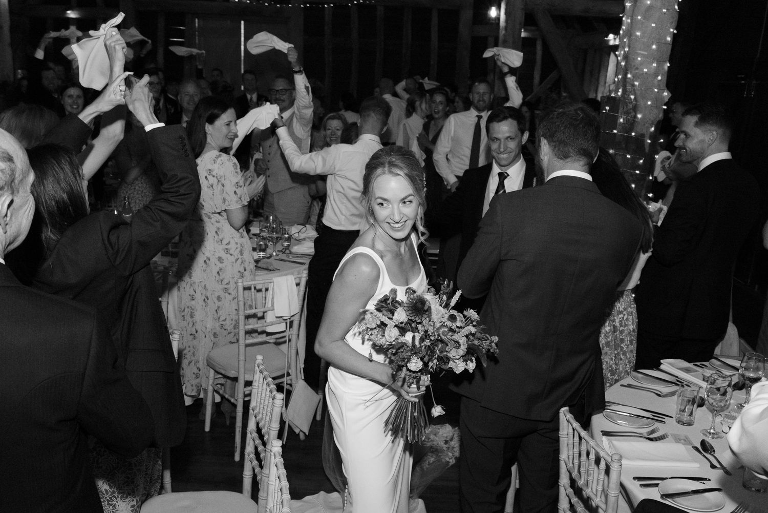 Bride and Groom entering their wedding breakfast, surrounded by their guests at Manor Barn, Cambridge