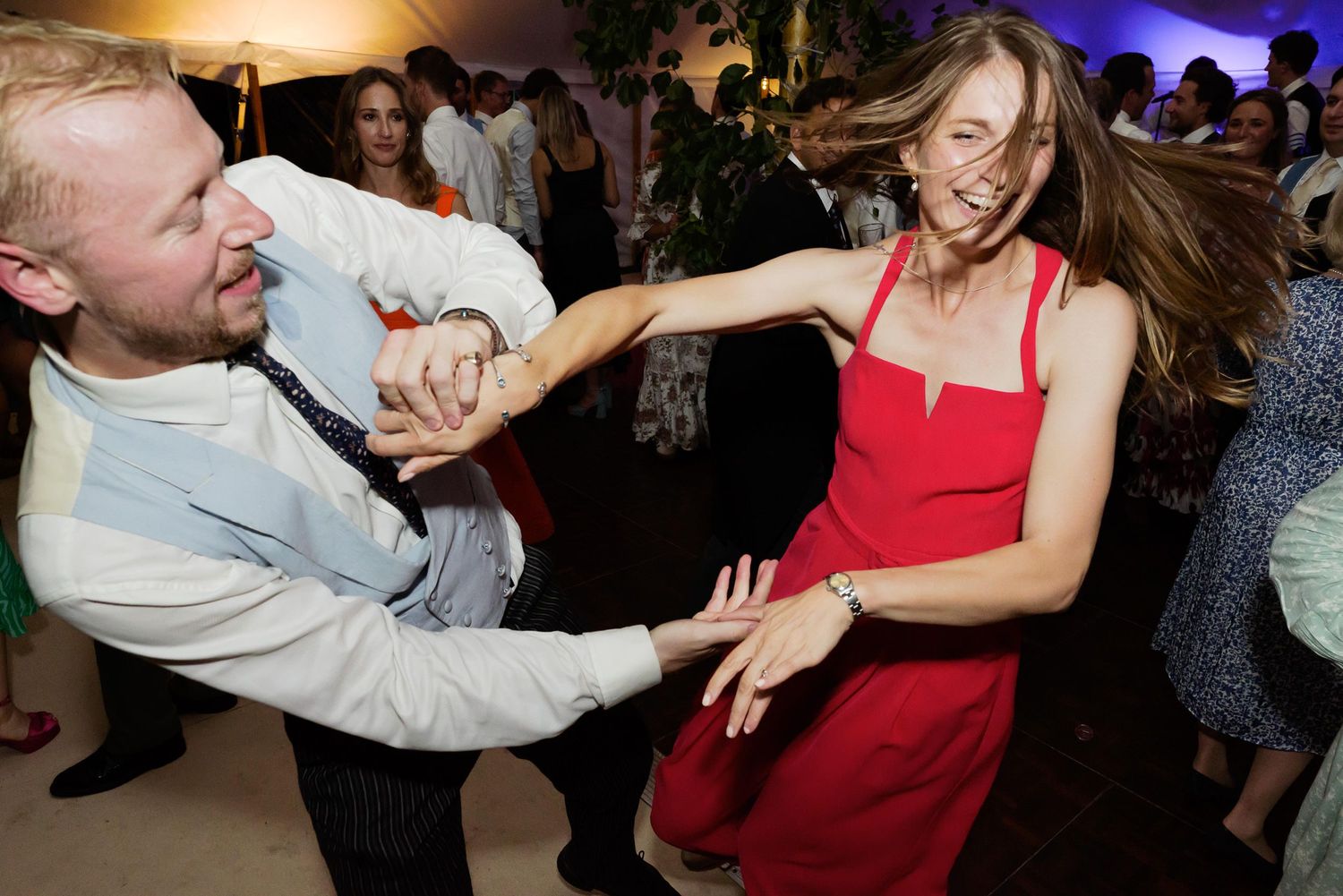 Energetic dancing and celebration at a wedding reception with guests in formal attire.