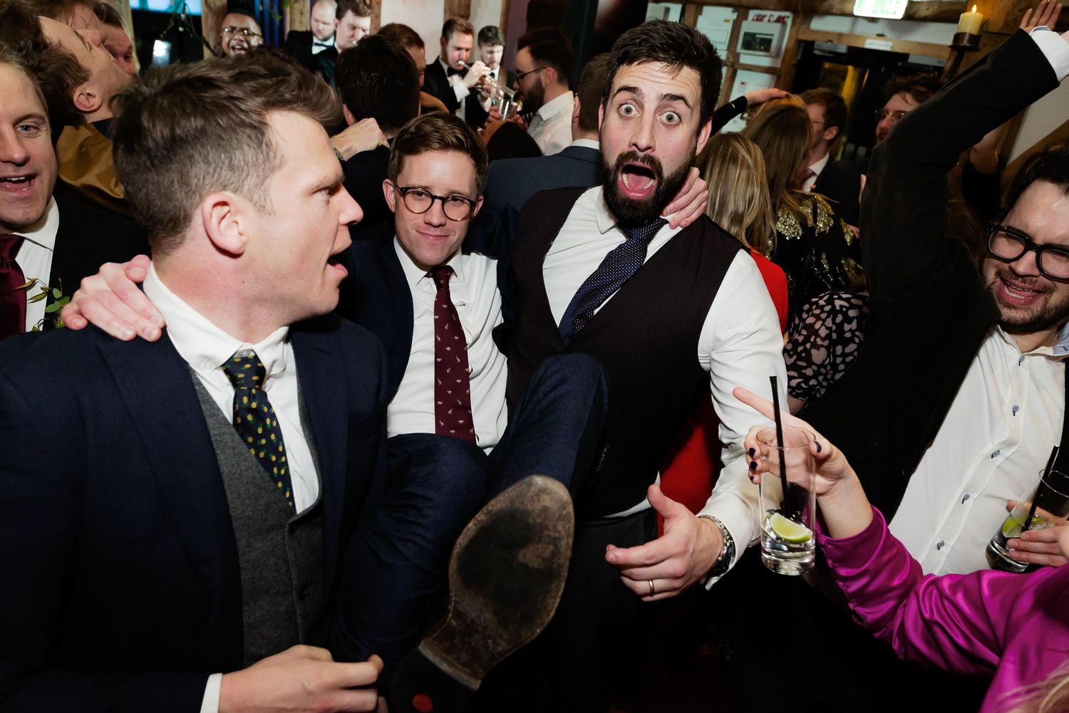 Animated group of wedding guests celebrating during reception party.
