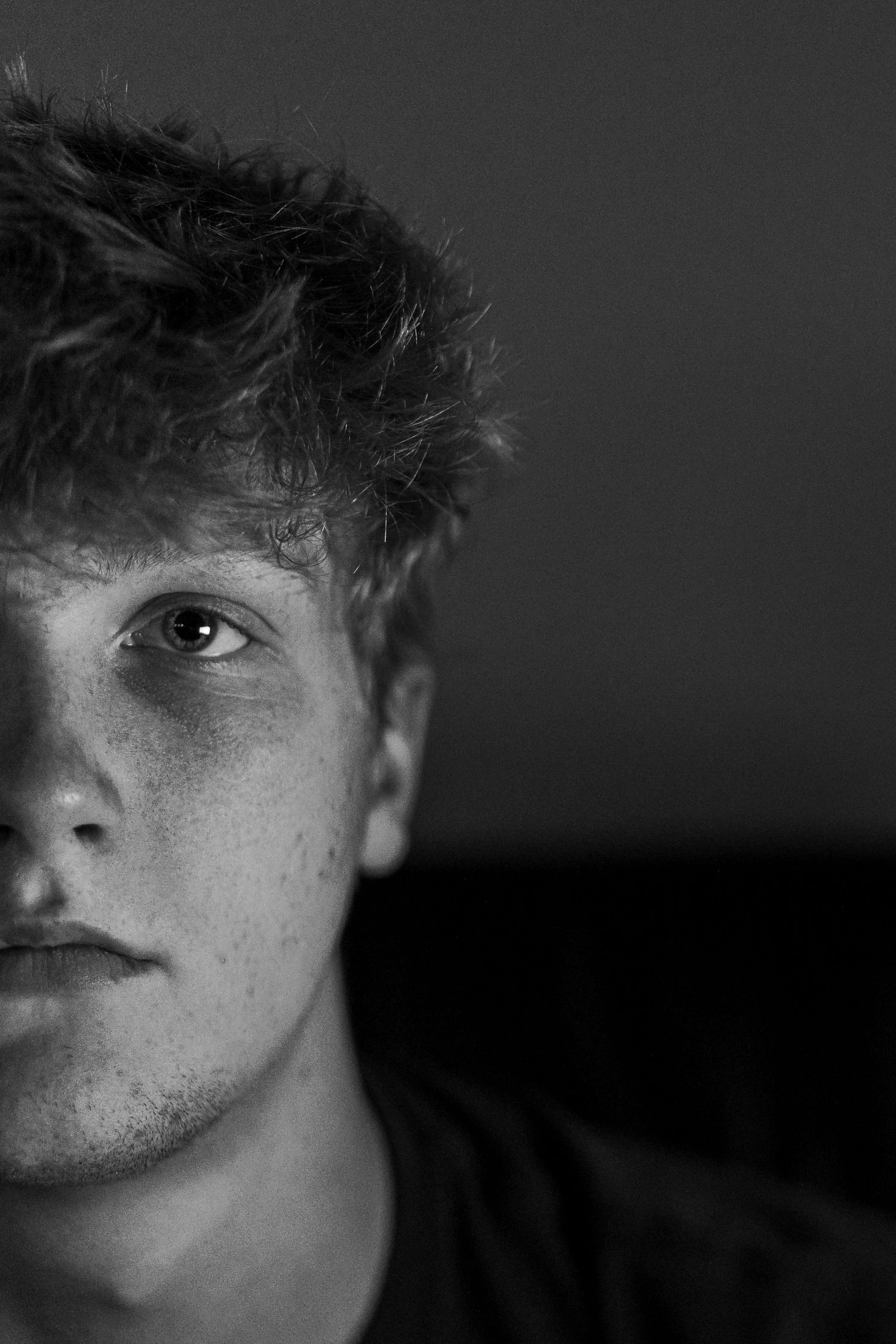Self-portrait of Jack Dalbey looking at camera with half of face.