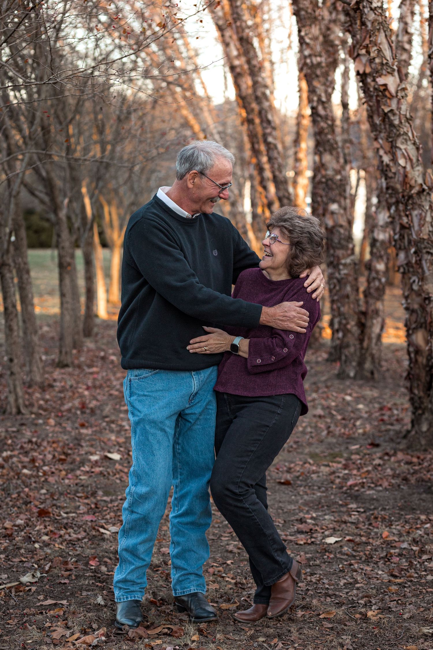 Couples photo in woods, capturing joy and laughter with a sunset. JDalbey Photography — couples portraits in Champaign IL.