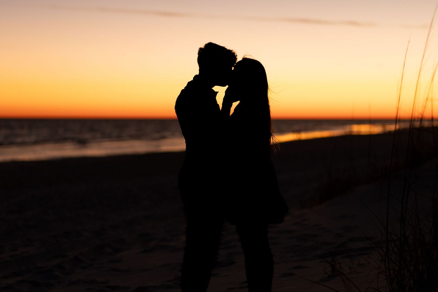 Couples photo at the beach, capturing a silhouette couple kissing JDalbey Photography — couples portraits in Champartraits.
