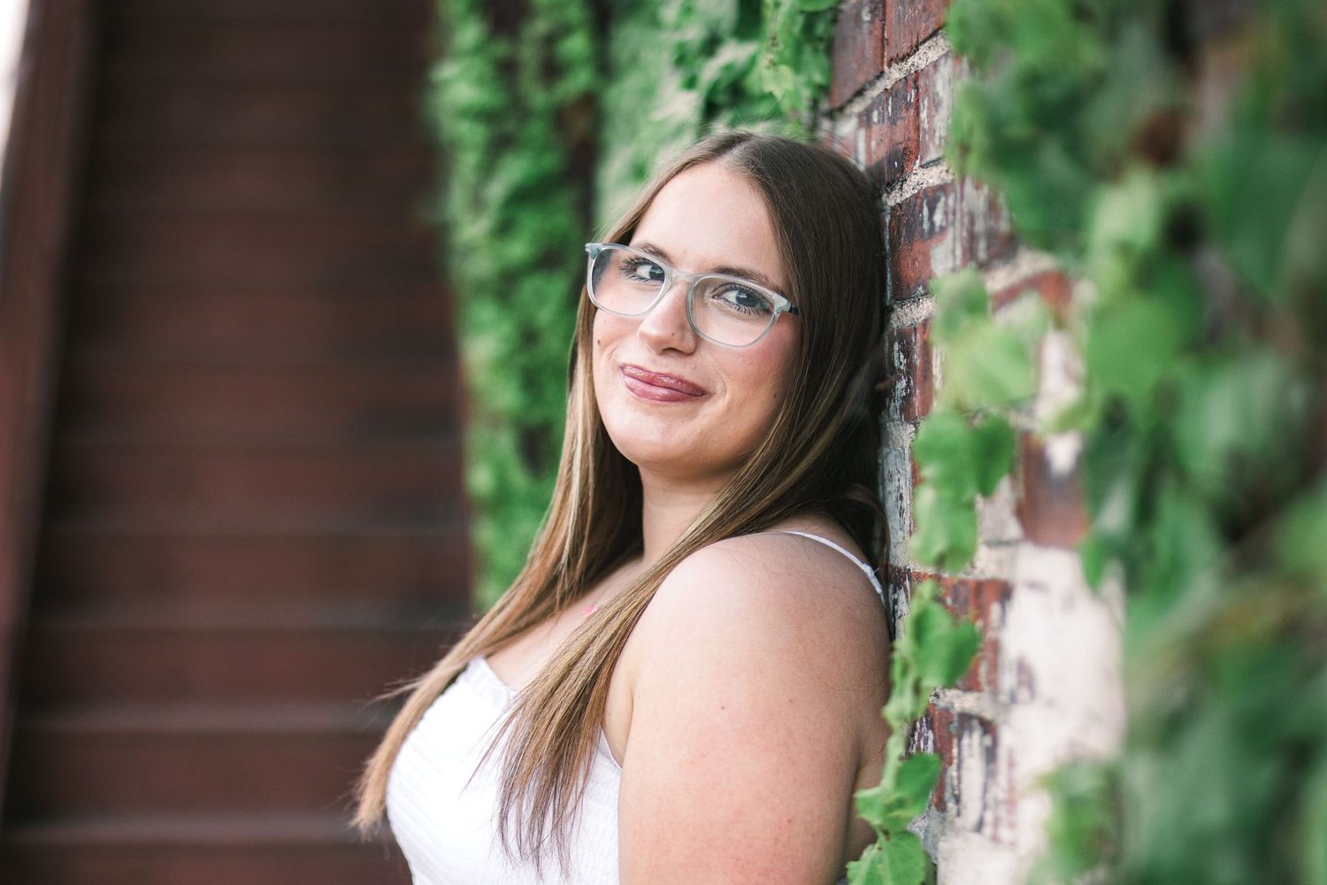 Senior portrait in downtown Champaign, showing girl leaning against wall with vines. JDalbey Photography — Champaign IL senior portraits.