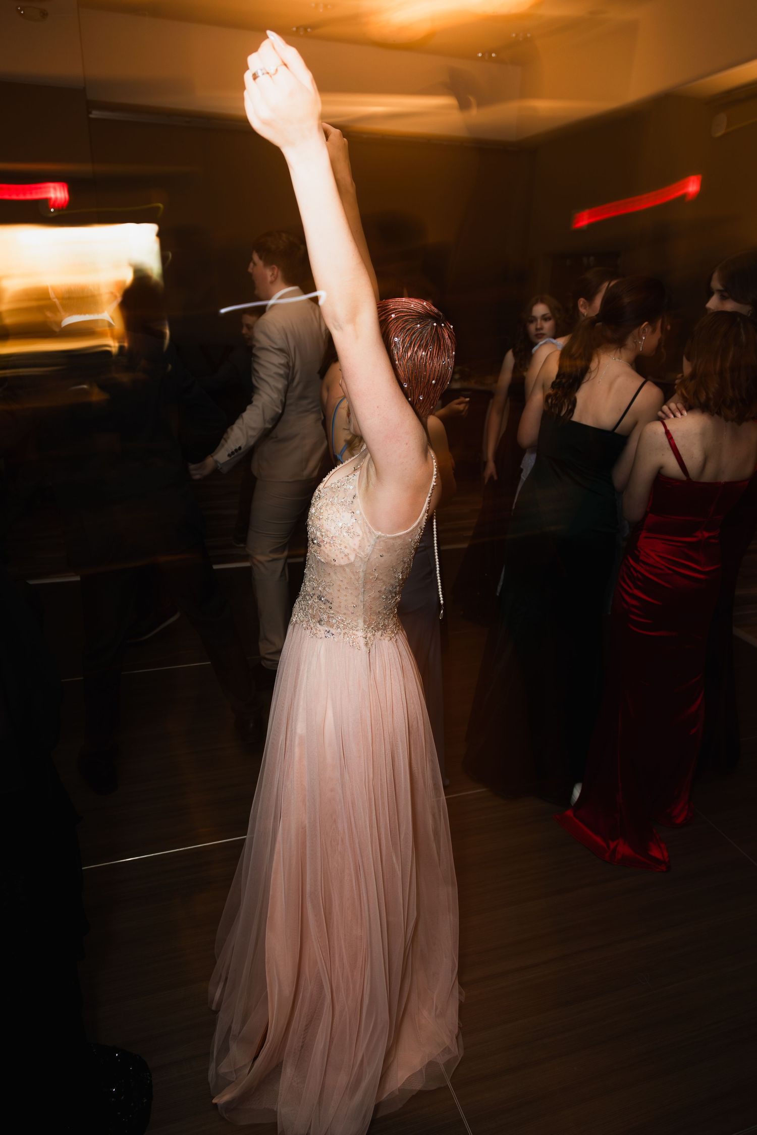 Solo portrait at prom, capturing a girl dancing on the dance floor with hands up. JDalbey Photography — couples portraits in Champaign IL.