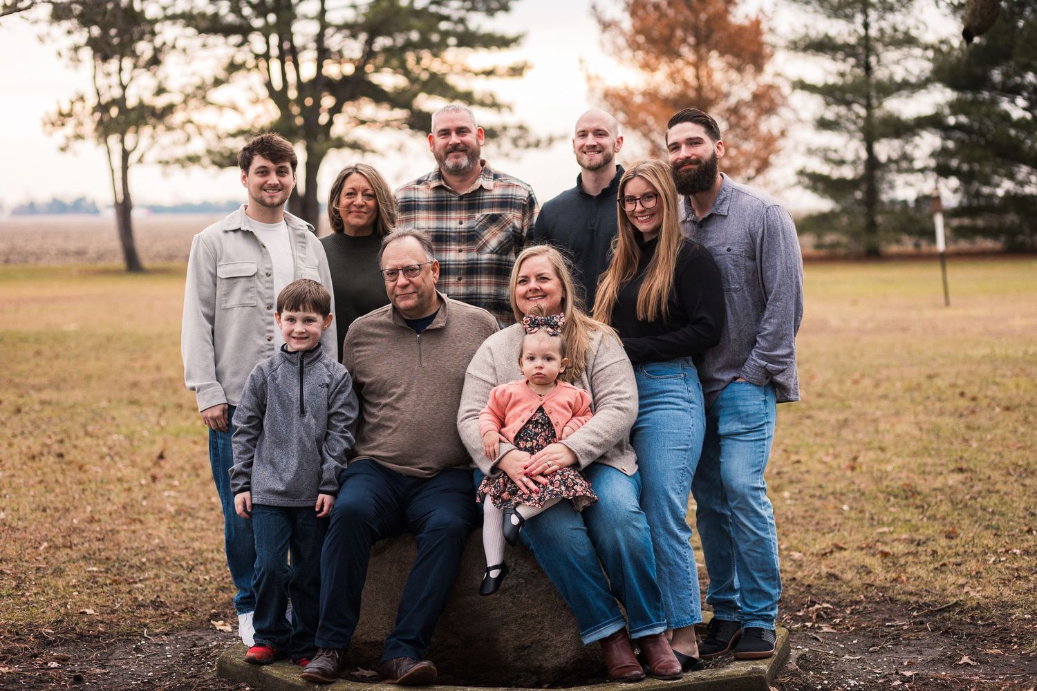 Family session in the field, showing a family of ten smiling together. JDalbey Photography — family portraits in Champaign, IL.