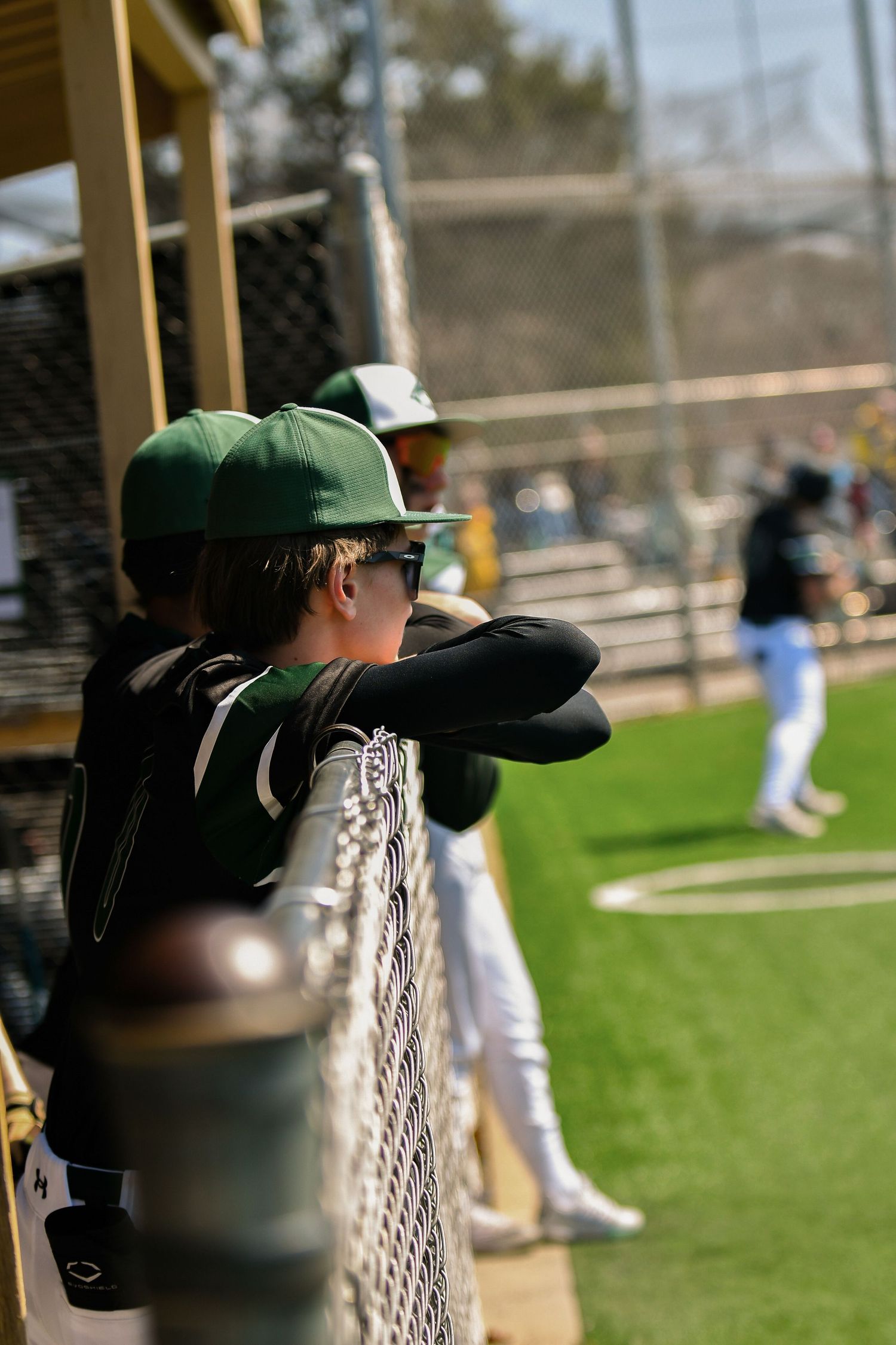 Baseball equipment and dugout view during a game on a sunny day. Nathan Hale High School Game Day to Grad Day Senior Portraits