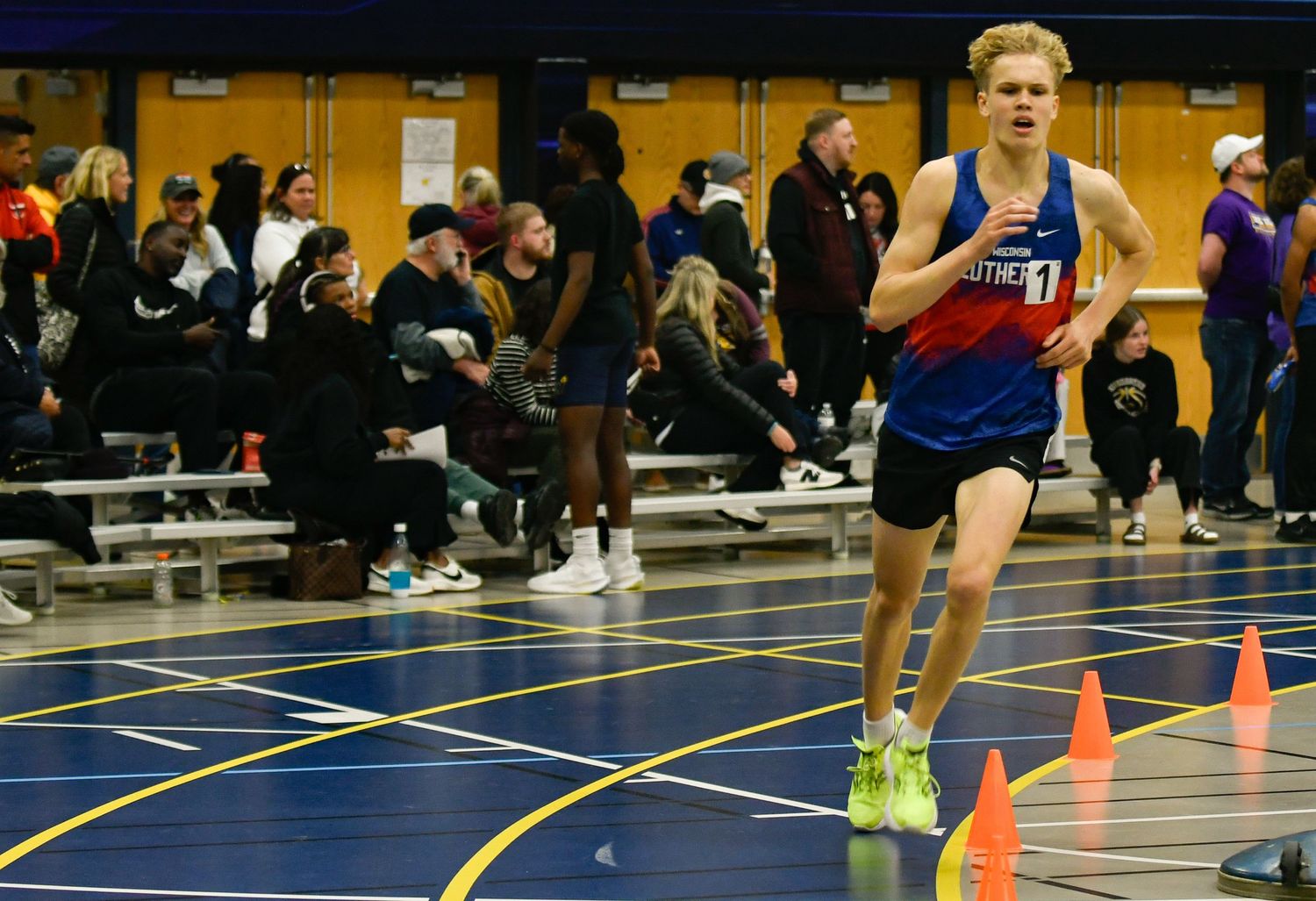 Athletes compete in an indoor track race with orange cones marking the course. Grounds Game Day to Grad Day Senior Portraits