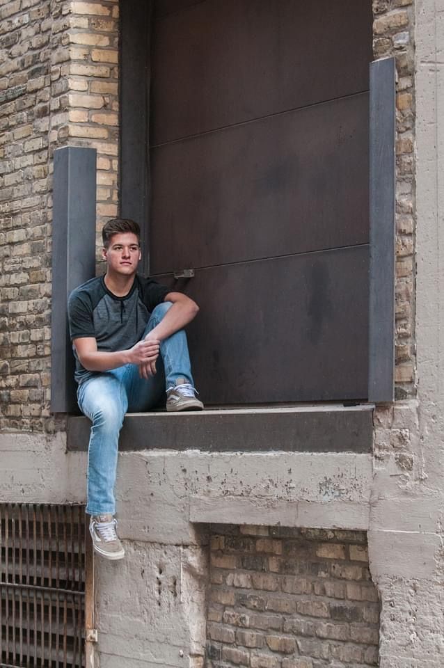 Urban high school senior portrait in architectural frame with exposed brick details in Milwaukee's Third Ward district.
