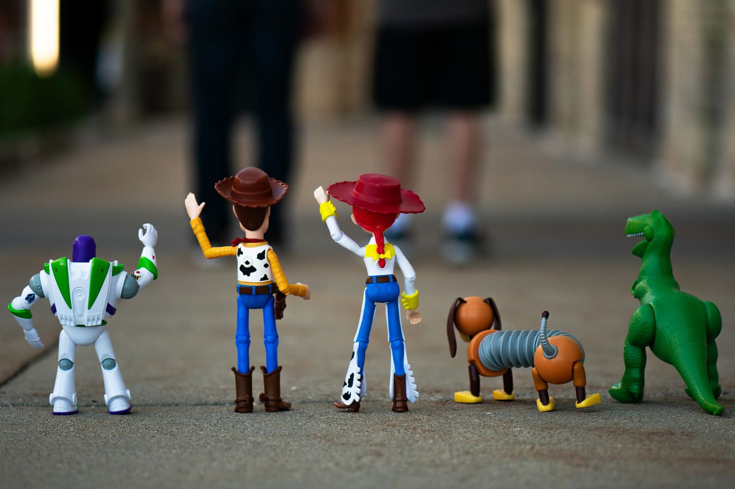 Colorful toy figures arranged in a line including dinosaurs and characters.