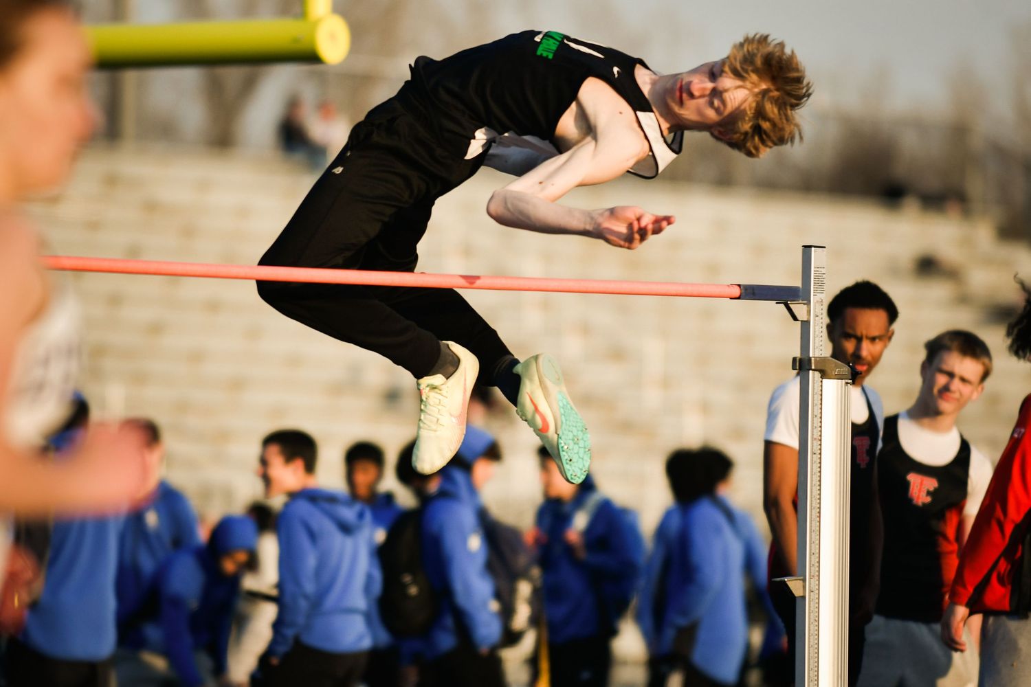 Athletes competing in high jump at a track and field event. Nathan Hale High School Game Day to Grad Day Senior Portraits