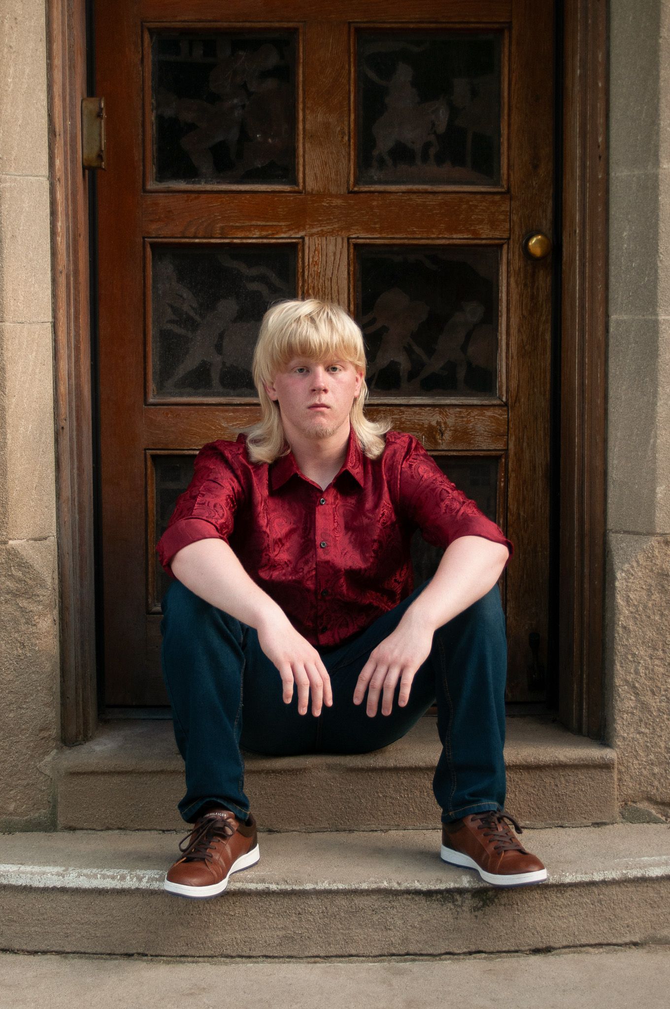 Senior high school posing in vintage doorway in the historic Best Place stone steps with with Simply Junique portrait photography.