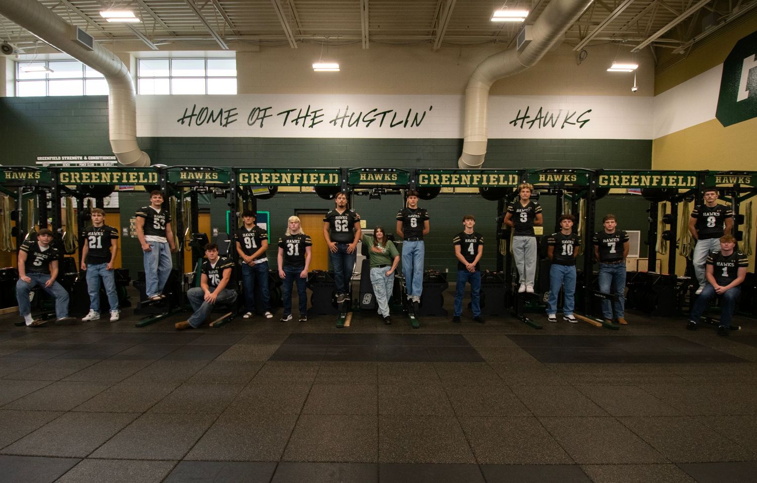 A panoramic view of a school gymnasium with banners and trophies displayed on the walls.