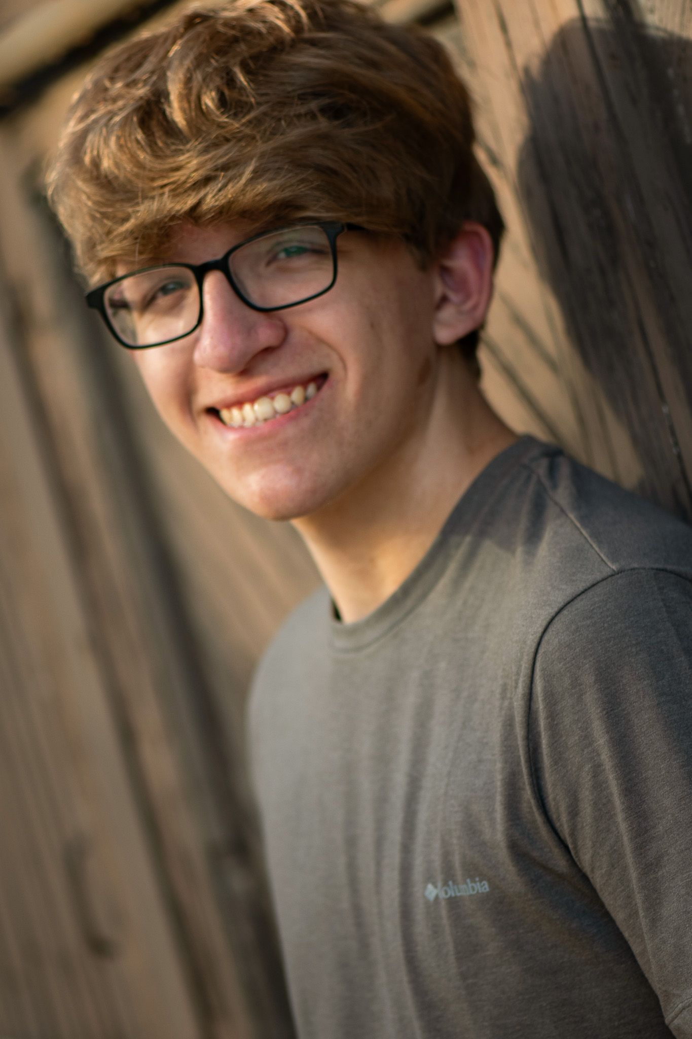 A high school senior portrait showcasing a boy against a shadowy backdrop in Milwaukee, WI