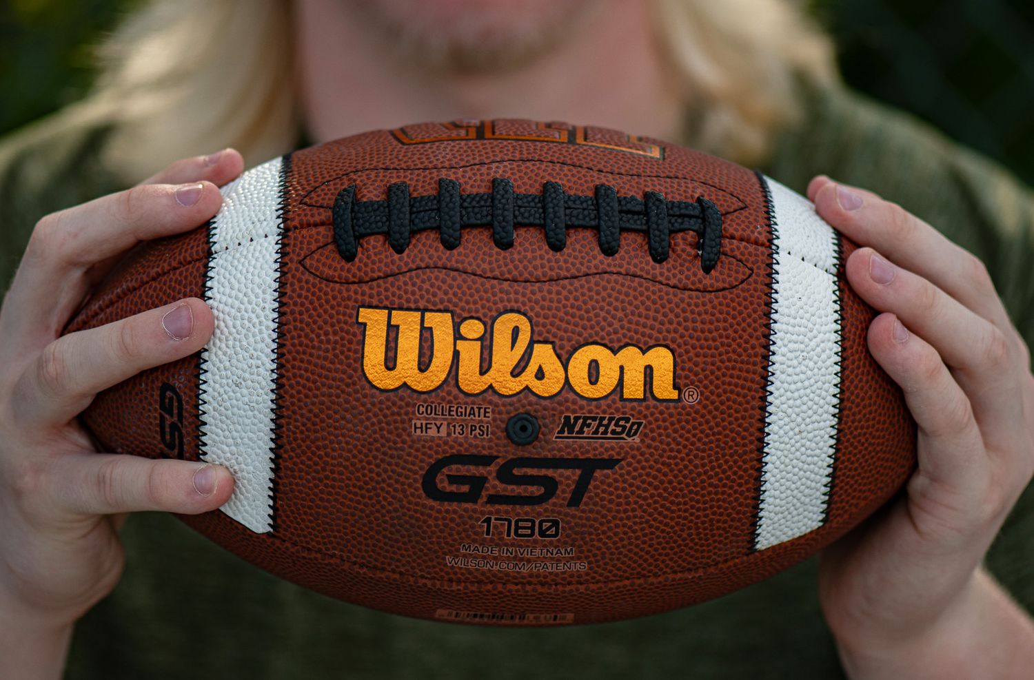 Close-up shots of Wilson football showing stitching and branding details. Game Day to Grad Day Senior Portrait Experience