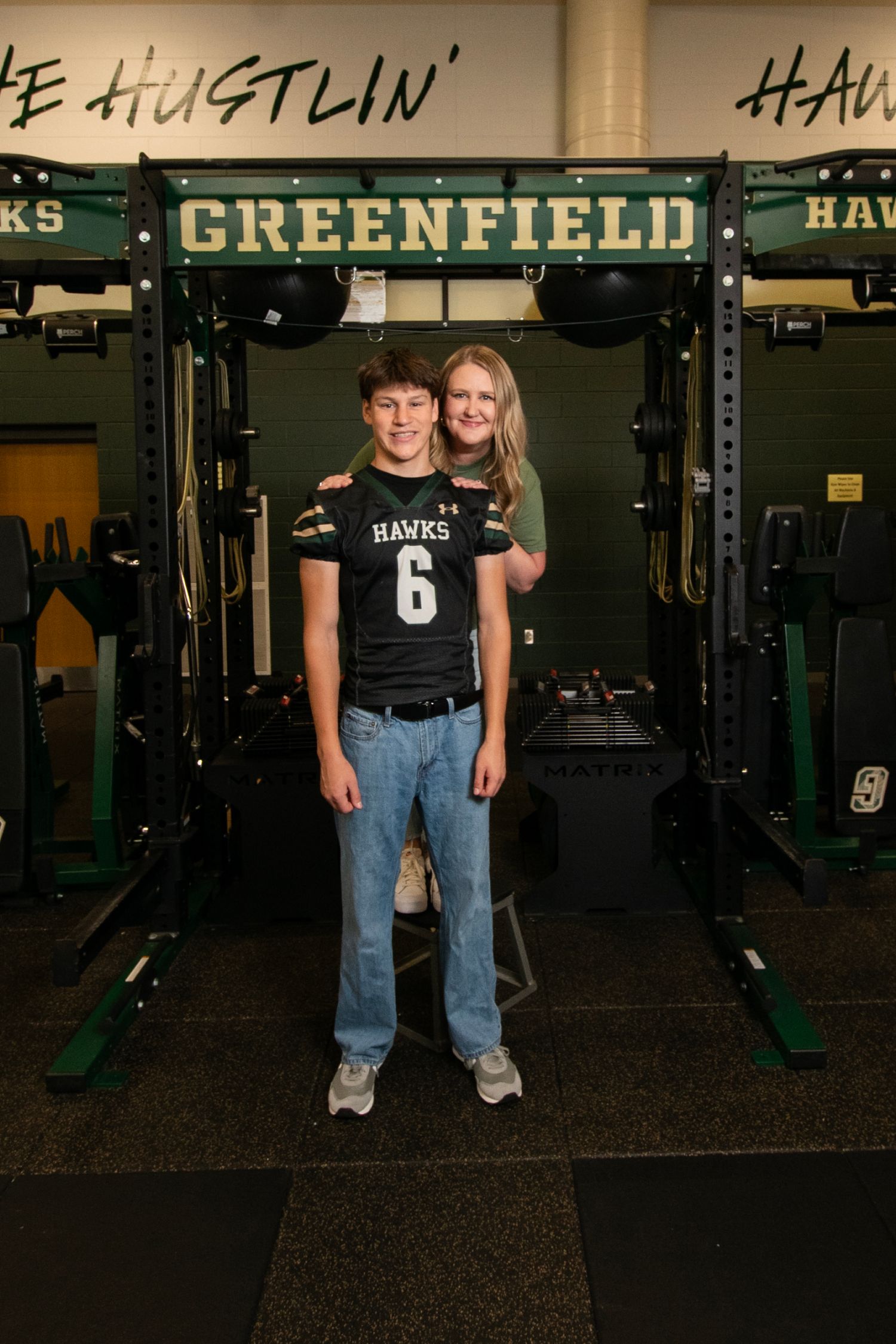 Athletic training facility with green and black weight equipment and 'Greenfield' signage displayed prominently.