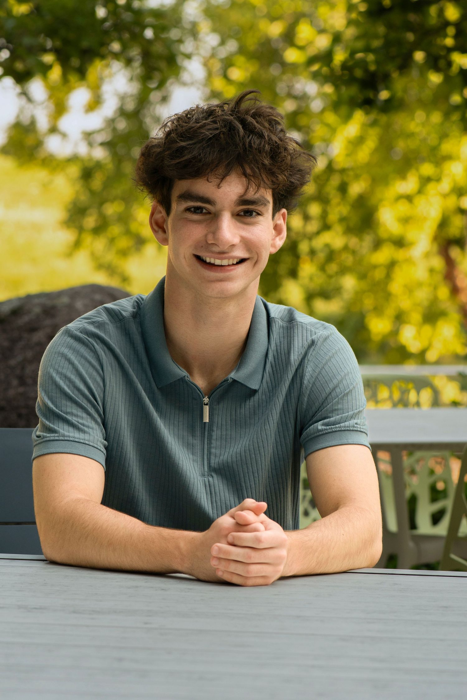 Outdoor portrait in a teal polo shirt with sunlit trees in the background. at Northwestern Mutual, Franklin Wisconsin Simply Junique
