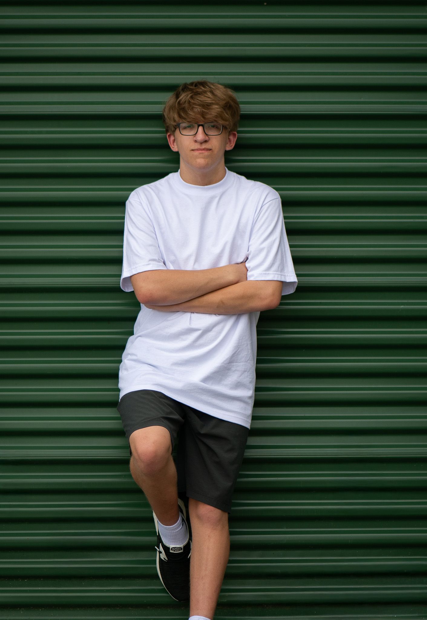 Modern portraits against green metal garage door background. Simply Junique Senior Portrait Experience Game Day to Grad Day