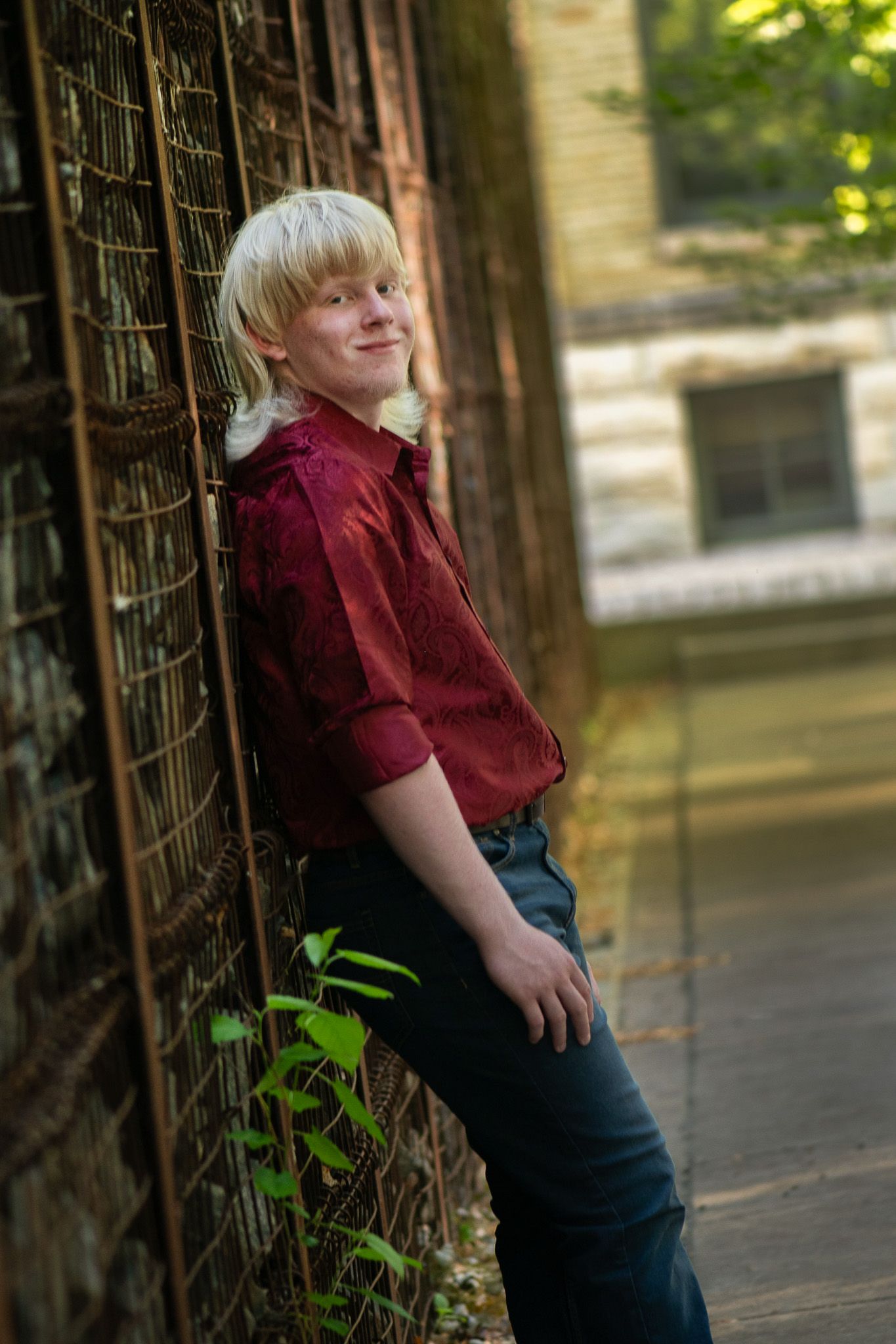 Outdoor portraits between wrought iron columns with natural lighting for a high school senior portrait session with Simply Junique