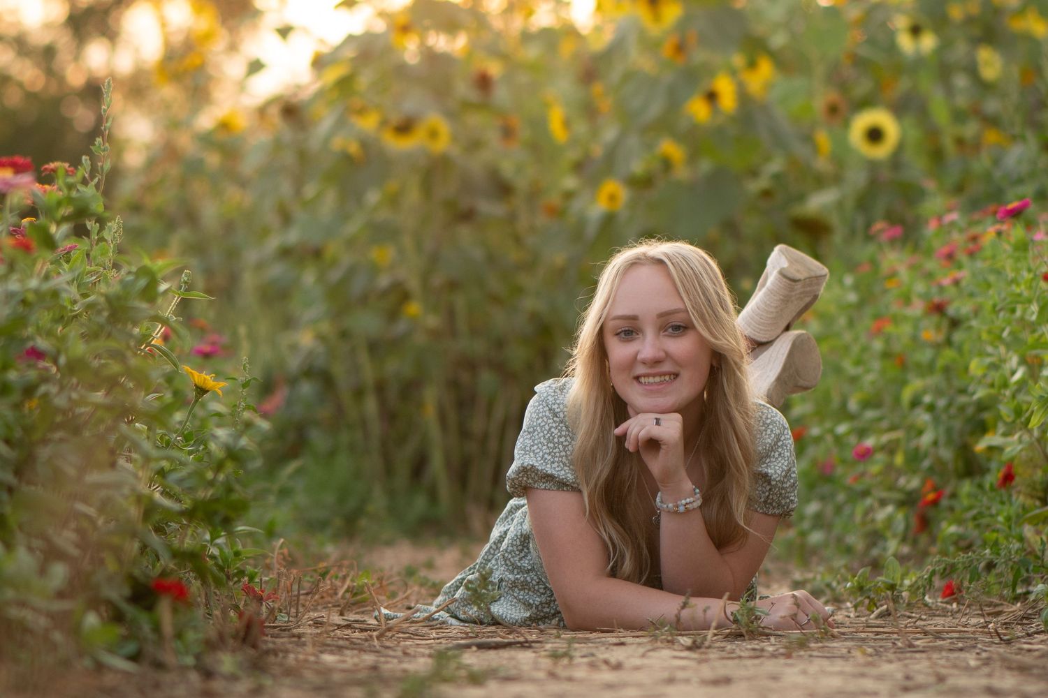 Senior portrait session in a field of sunflowers during golden hour.