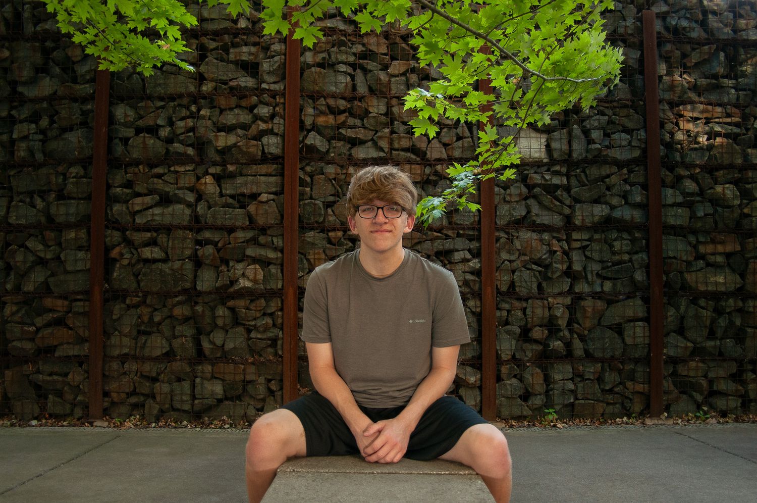 Outdoor portraits against stone wall with climbing vines. Simply Junique Senior Portrait Experience Game Day to Grad Day