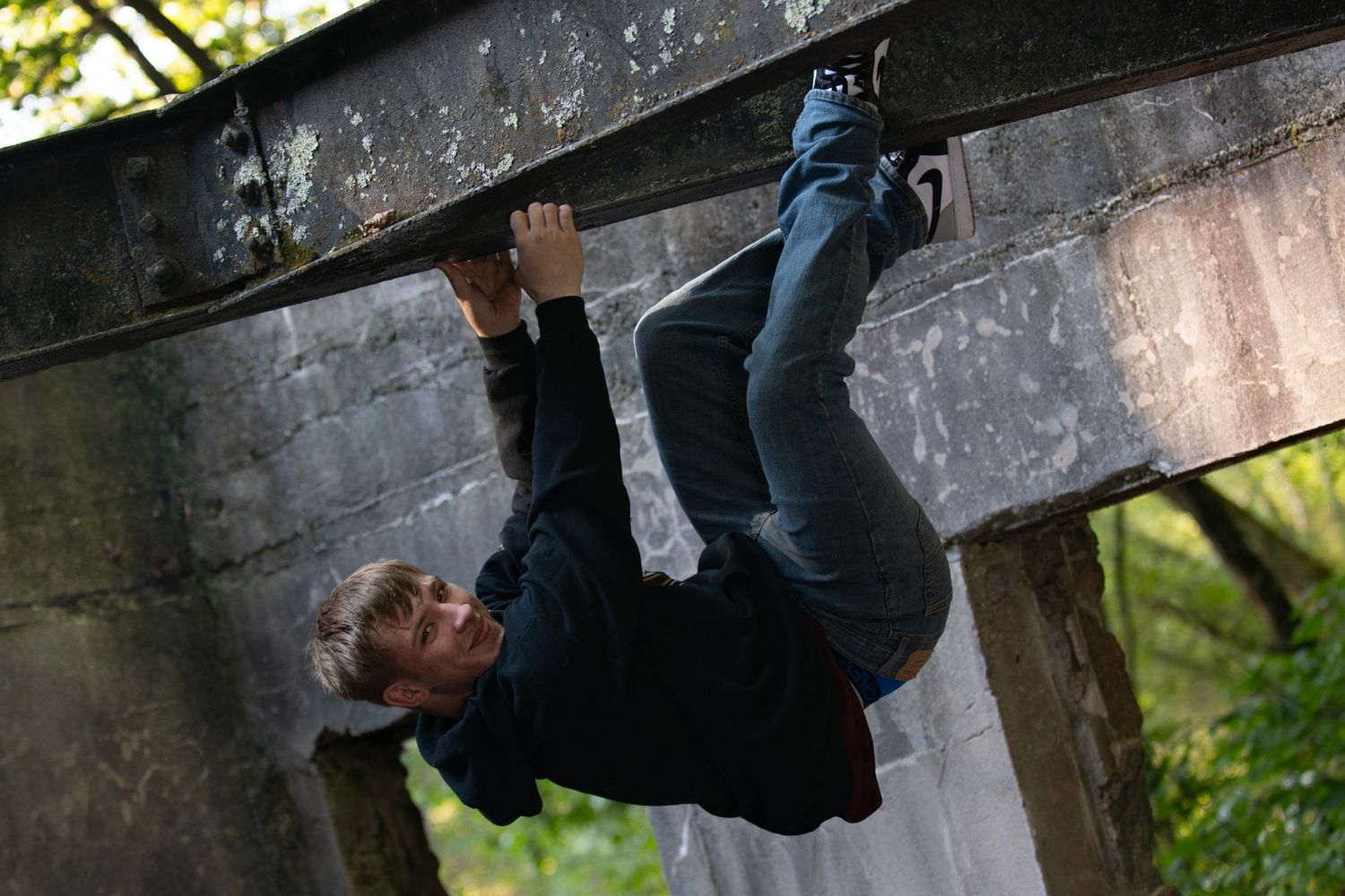 A person in climbing gear demonstrates various rock climbing moves and techniques on an indoor climbing wall.
