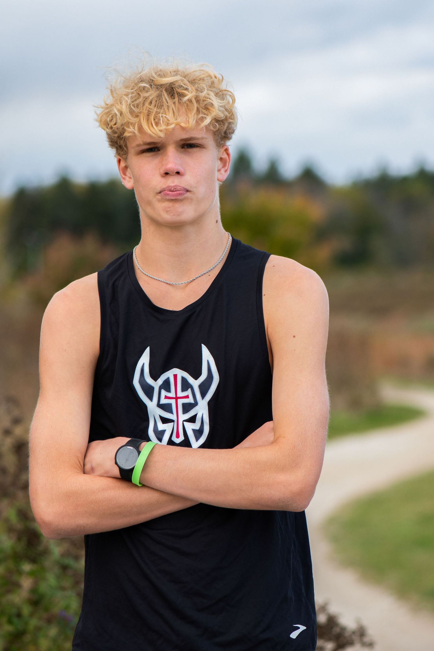 Athlete in black tank top with logo posing outdoors on trail. Milwaukee County Grounds Simply Junique Portraits