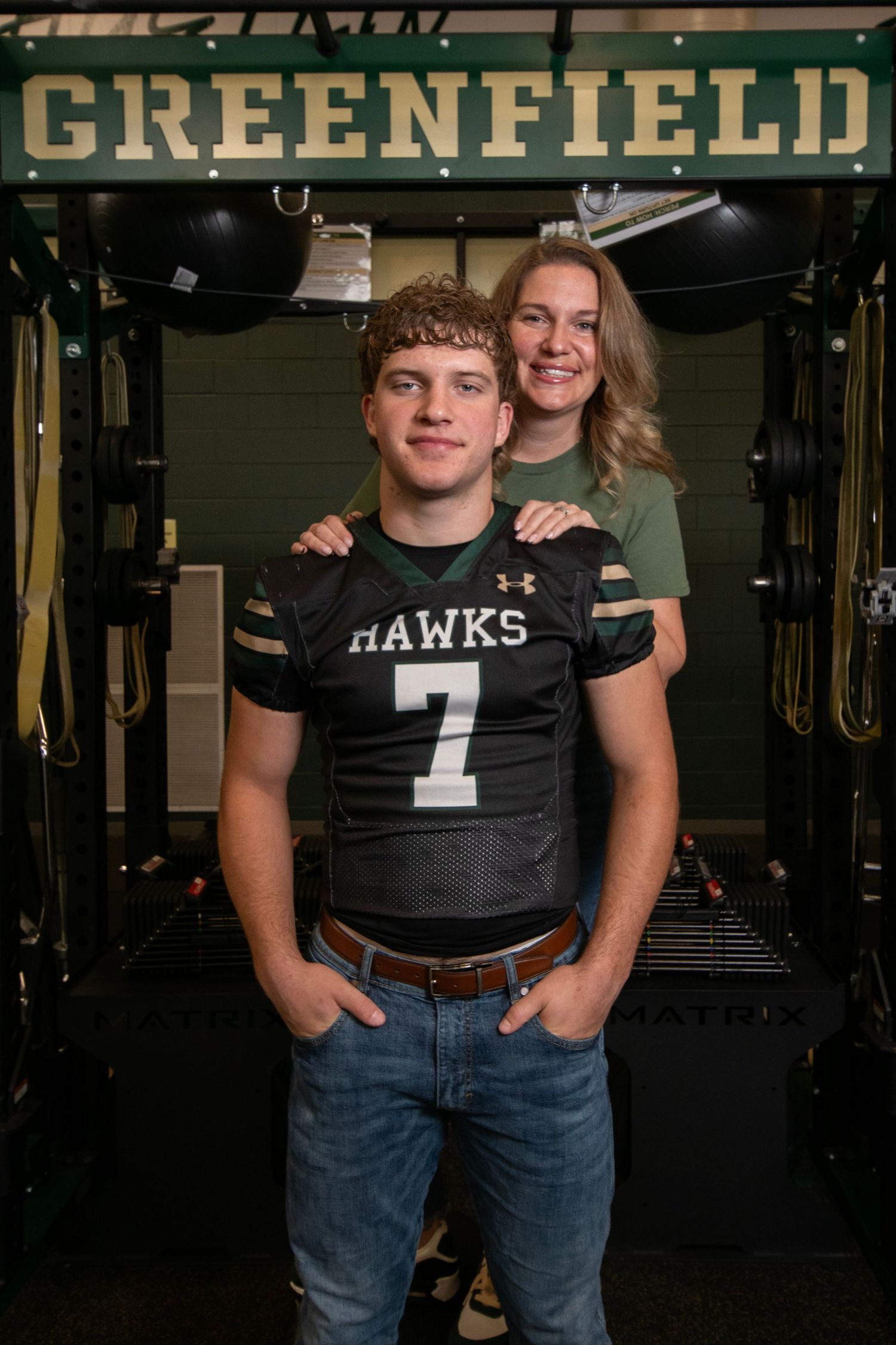 A series of similar photos showing two people posing together in a dimly lit indoor space with a Greenfield sign visible.