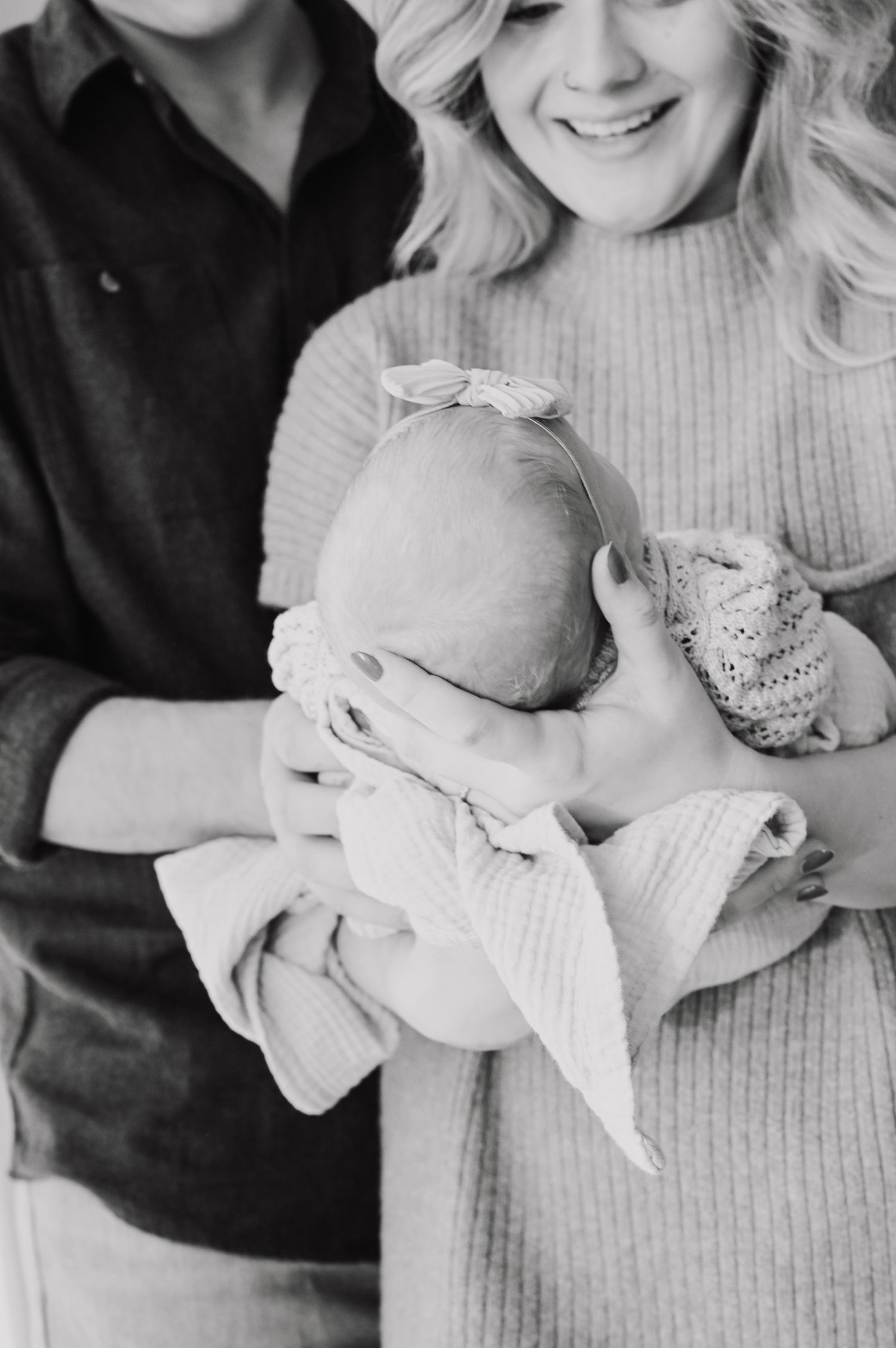 Black and white images of baby being held in soft knit sweater.