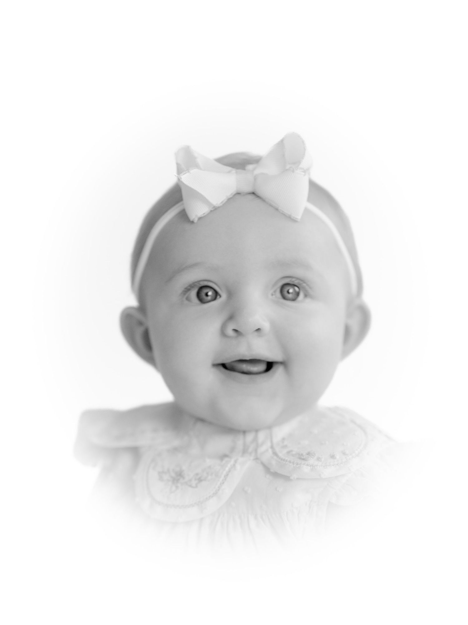 High key black and white close-up baby portraits showing different expressions.