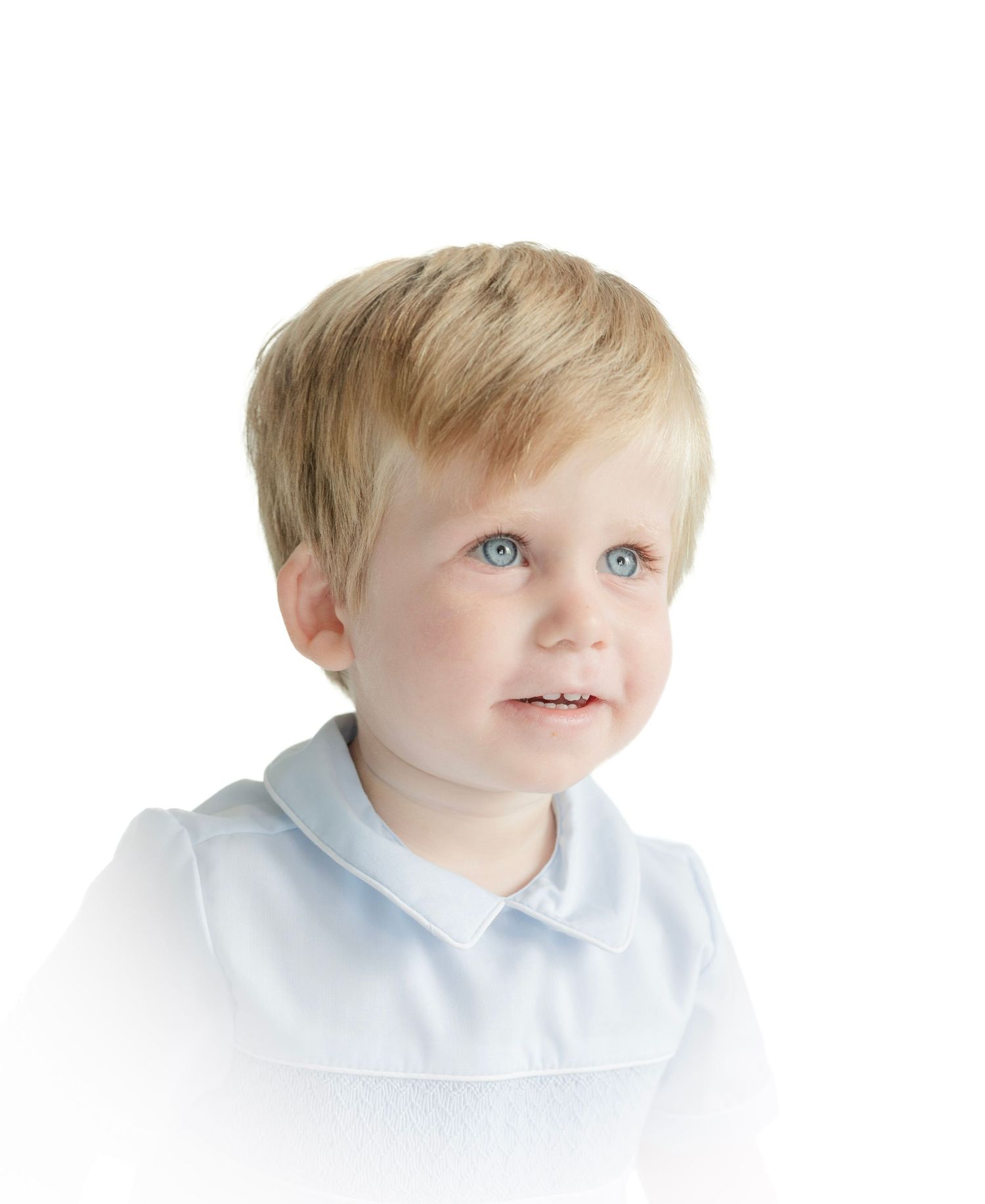 Portrait series of toddler in light blue collared shirt showing various expressions.