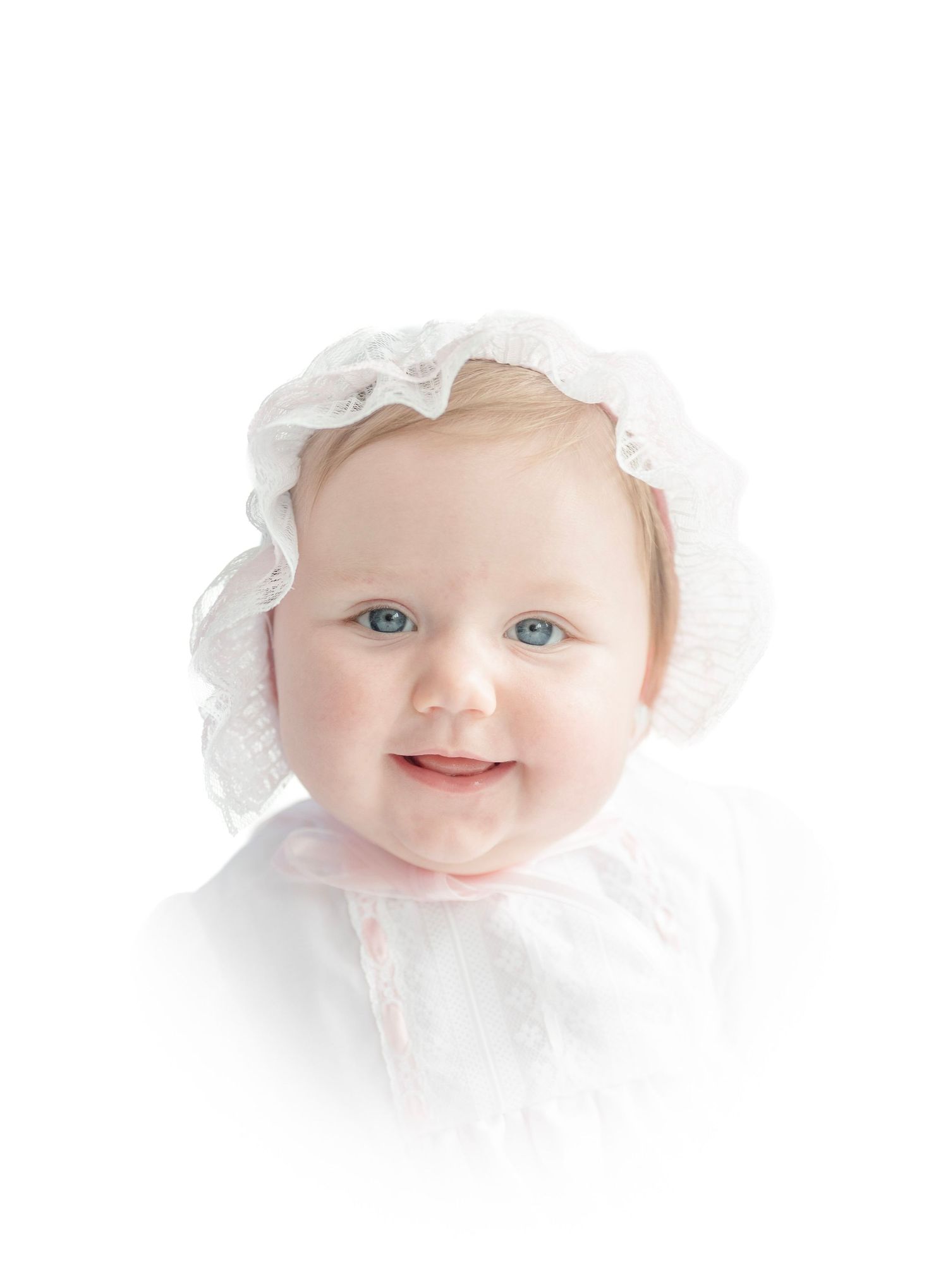 Close-up artistic portraits of a baby wearing white lace showing different expressions against light background.