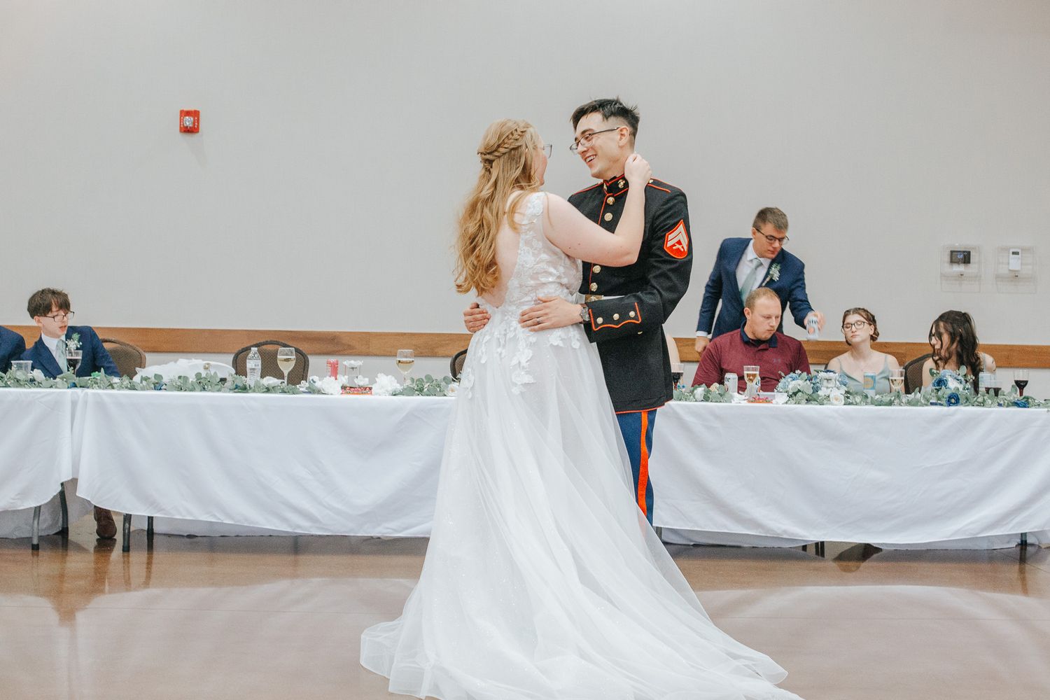 Wedding guests dance together during a reception celebration in a decorated banquet hall.