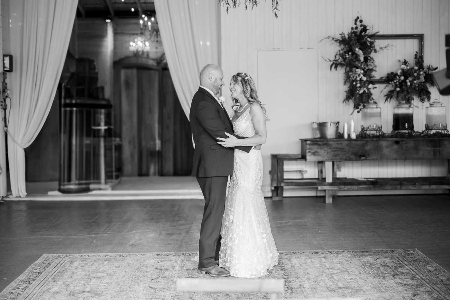 Black and white photo of couple during their first dance in elegant wedding venue.