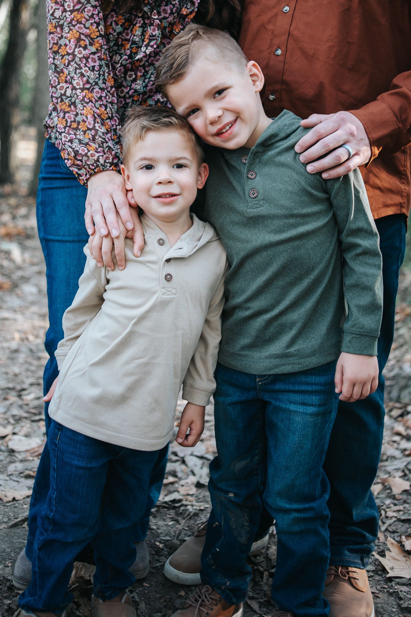 A series of candid family photos showing a parent and child in casual clothing standing together on fallen leaves.