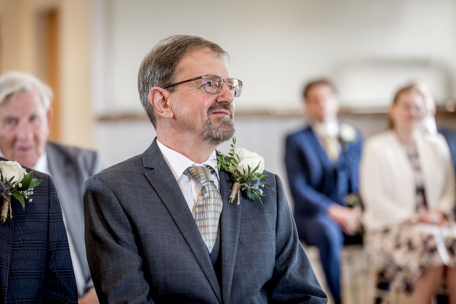 Guest in formal attire watching the wedding ceremony proceedings.