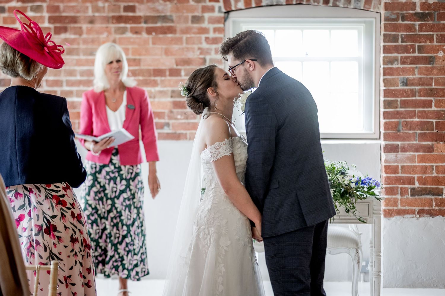 Wedding celebration in a light-filled room with exposed brick architecture.