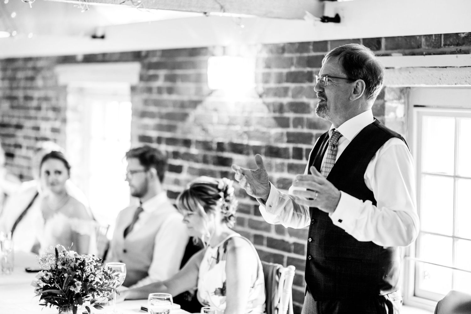 Wedding reception venue with exposed brick walls and white decor elements.