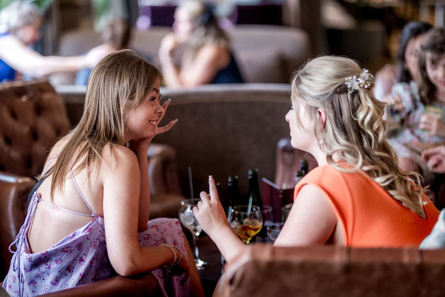 Guests enjoying conversation at a social gathering in warm ambient lighting.