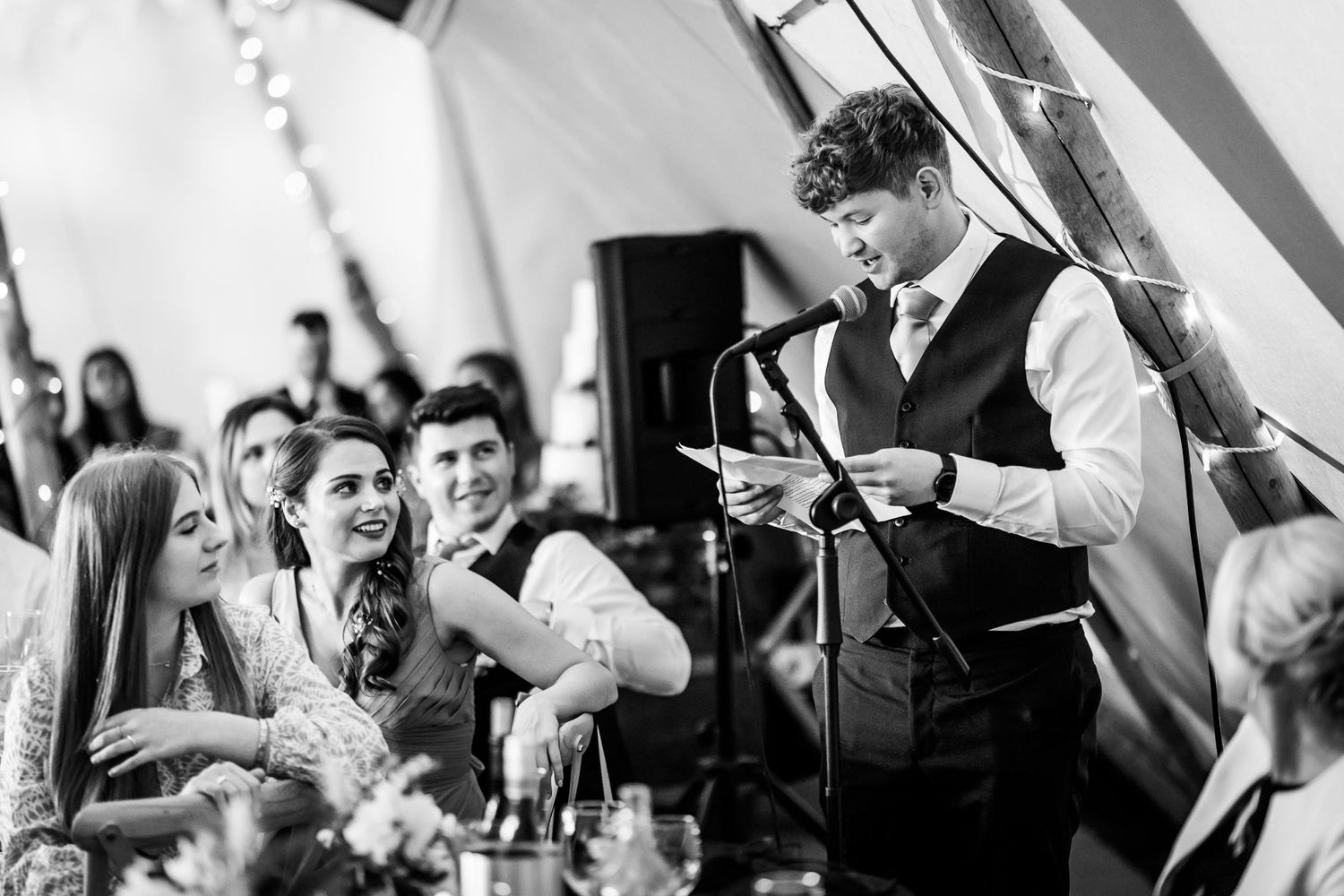 Black and white shots of wedding guests reacting emotionally during speeches.