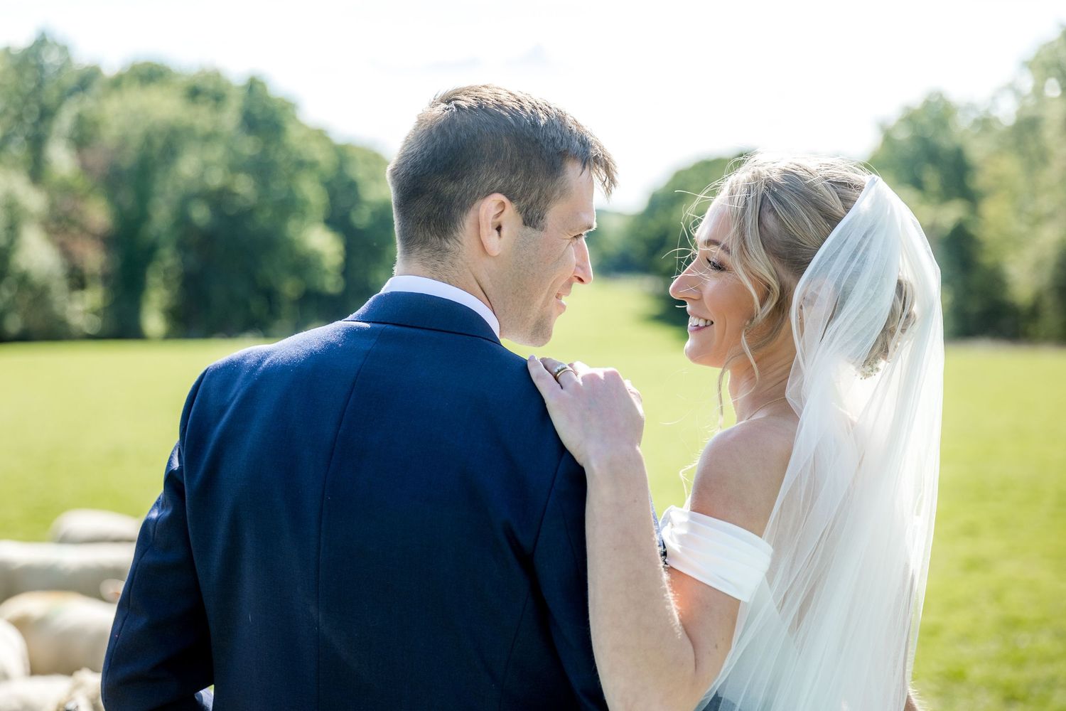 Wedding couple shares intimate moments in a sunny garden setting.