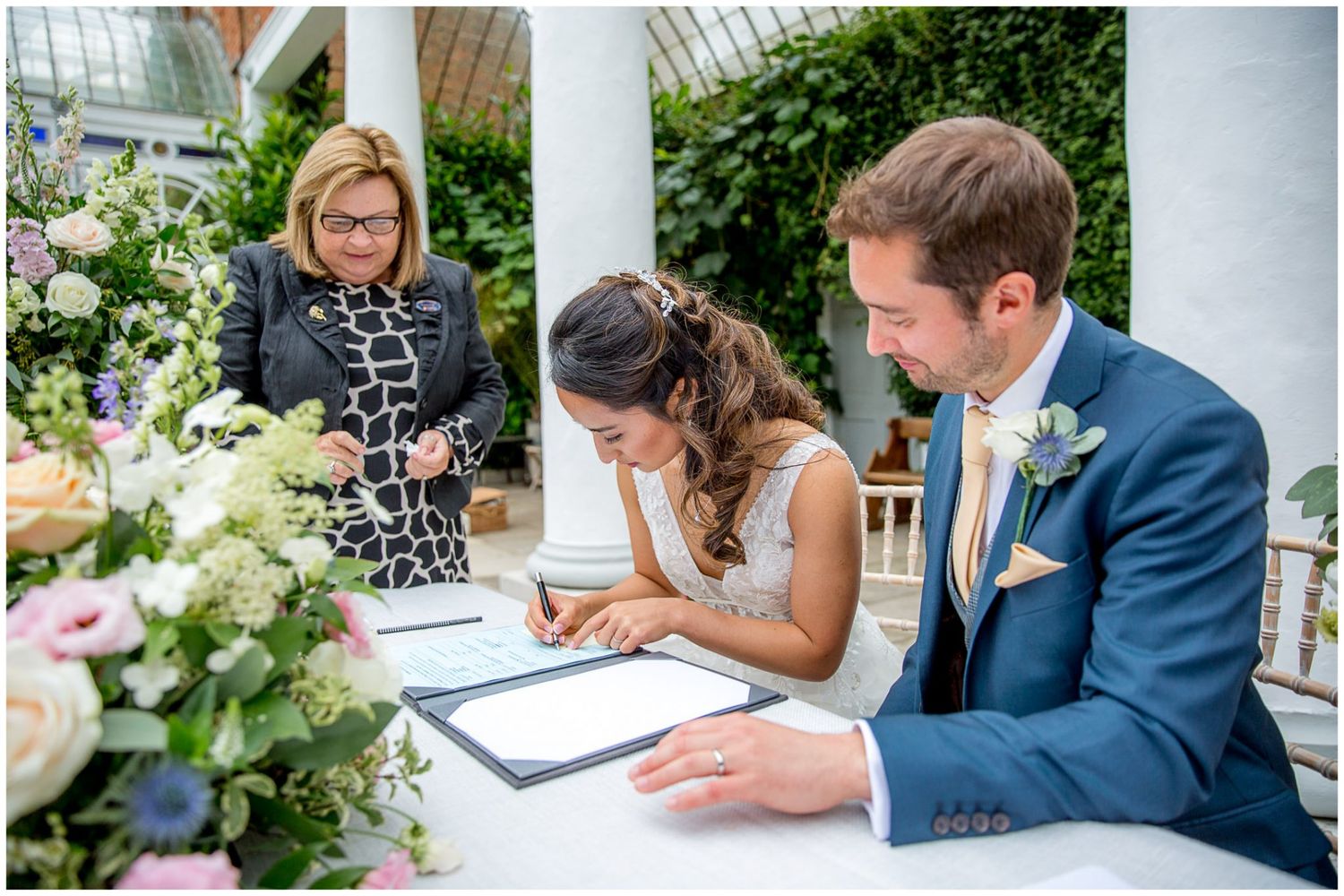 Wedding guests signing the official marriage register at an elegant venue.