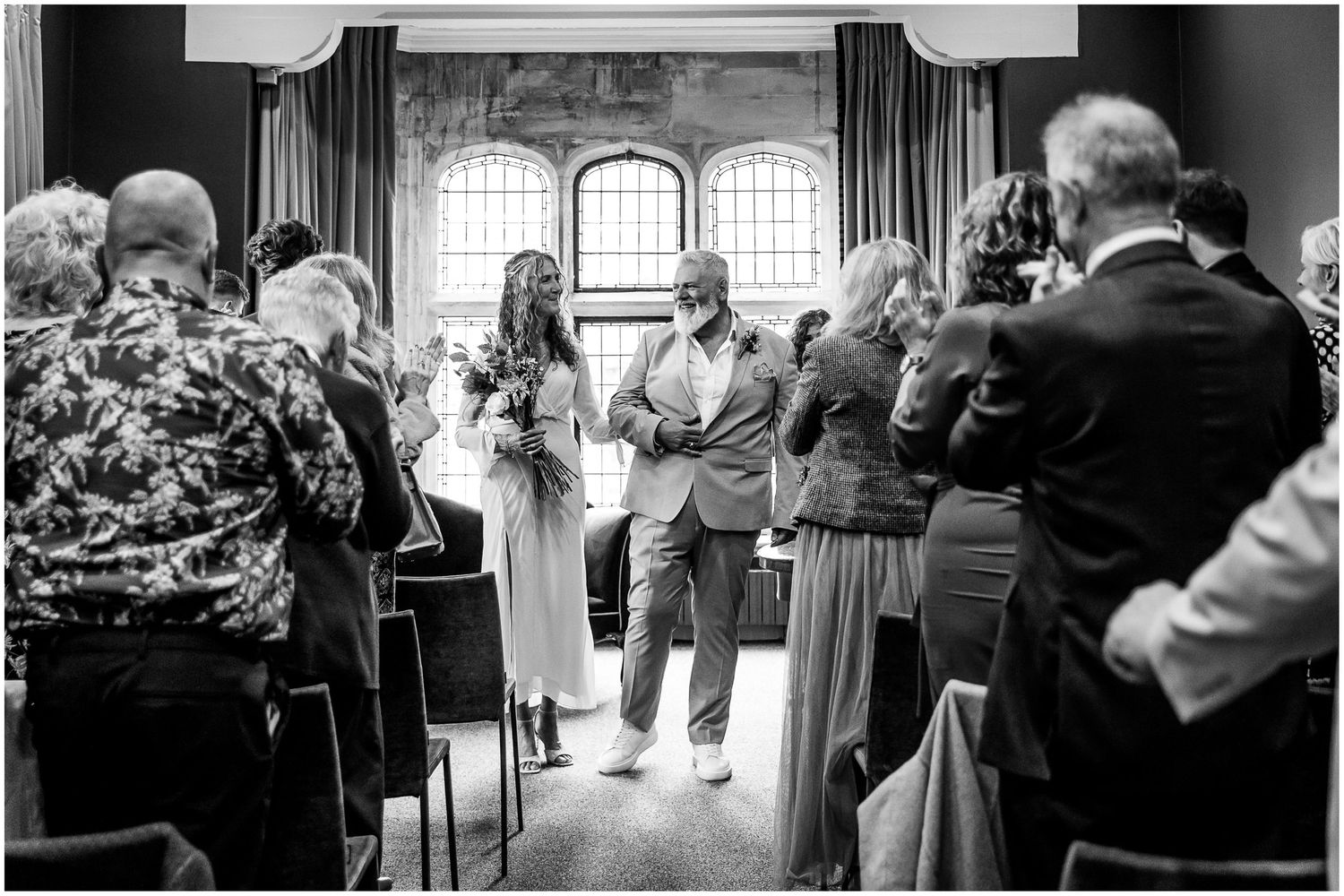 The newly married couple walk down the aisle of the Castle Room in Winchester at the end of the marriage service