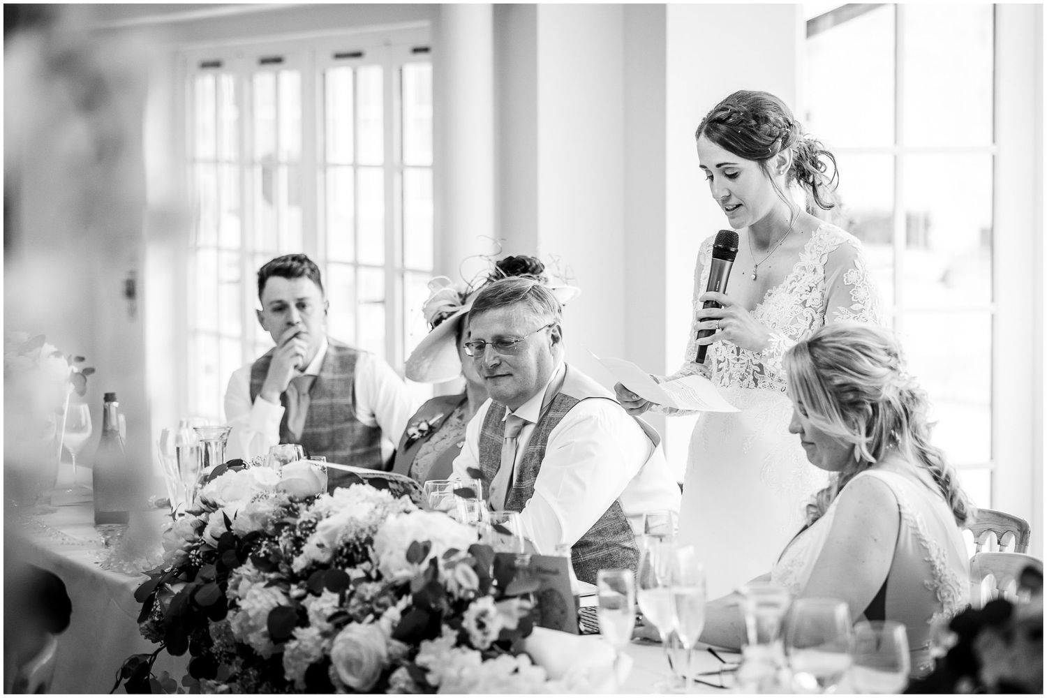 Elegant wedding reception setup with floral centerpieces and natural lighting.