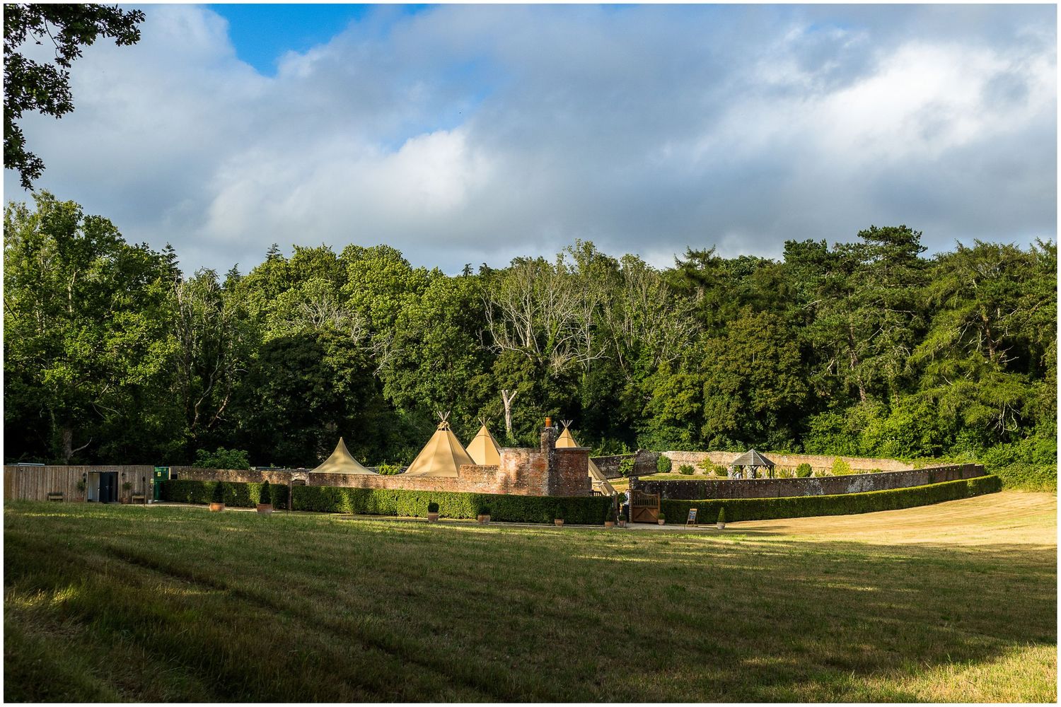 A view of the wedding marquee tipi and walled garden of the Holywell Estate in the Summer sunshine
