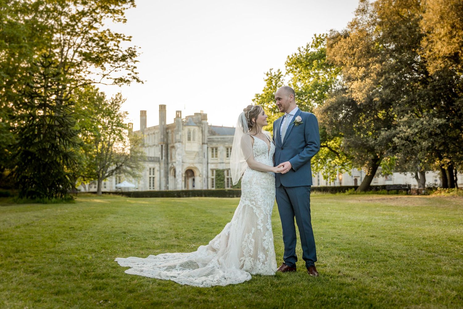 Elegant garden ceremony setting with autumn trees and classical architecture in background.