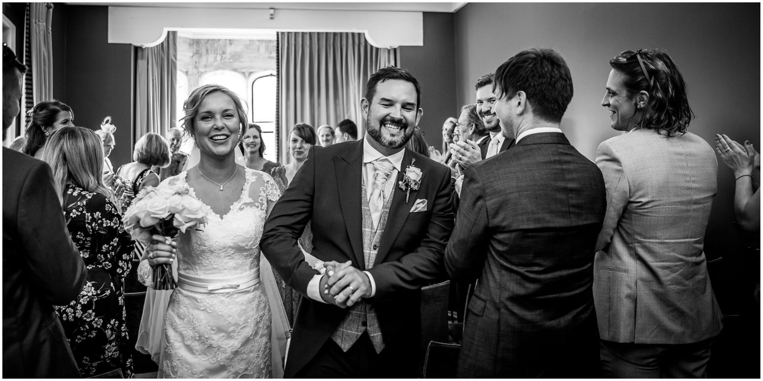 Black and white wedding reception photos show guests dancing and celebrating at an elegant indoor venue.